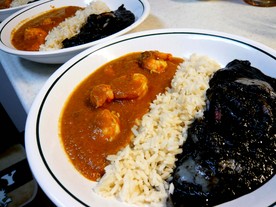 黄色と黒のシーフードカレーの画像